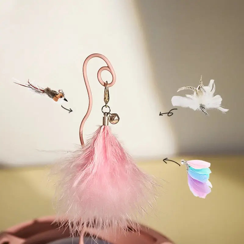 Jouet interactif design : plume rose et oiseau blanc sur la table pour un jeu de chat élégant