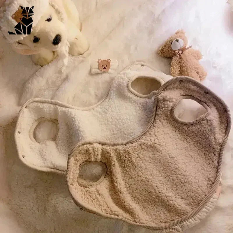 Lit de bébé avec ours en peluche et animal en peluche présentant le manteau Comfort Coat de Polaire pour chiens et chats